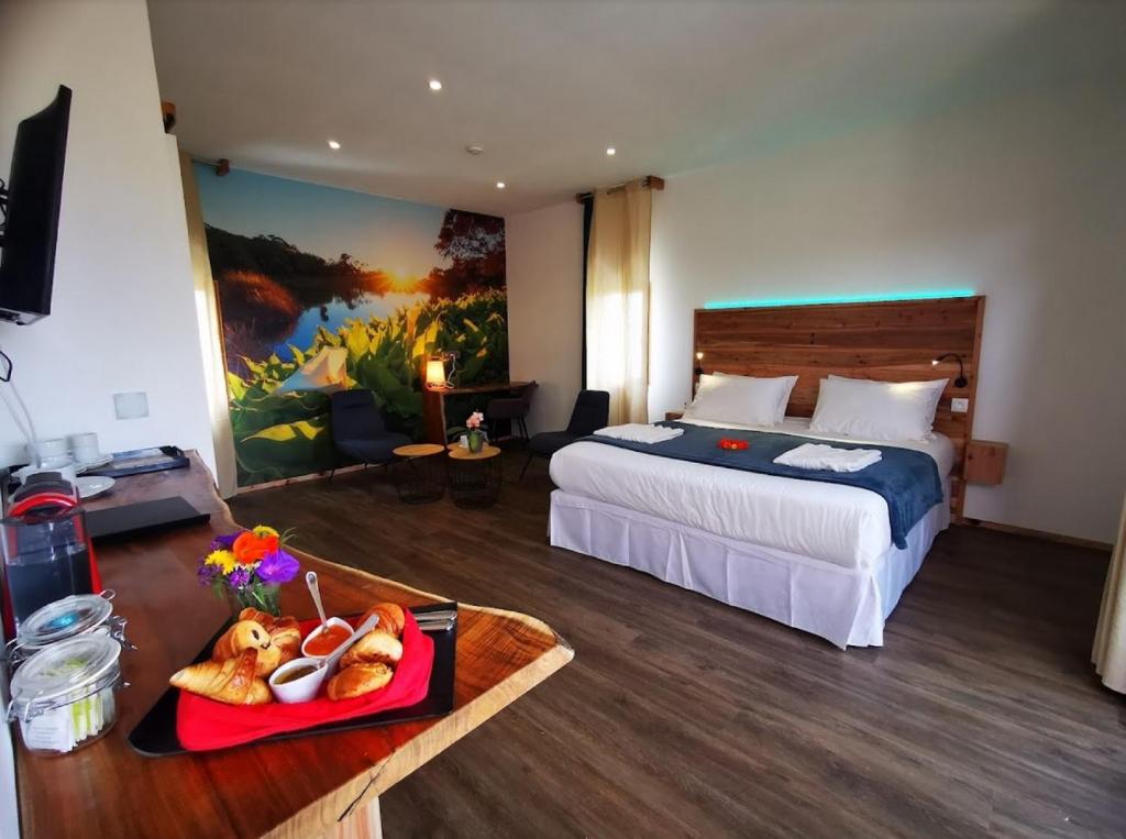 勒唐蓬Tamar'Inn的一间酒店客房,配有一张床和一盘食物
