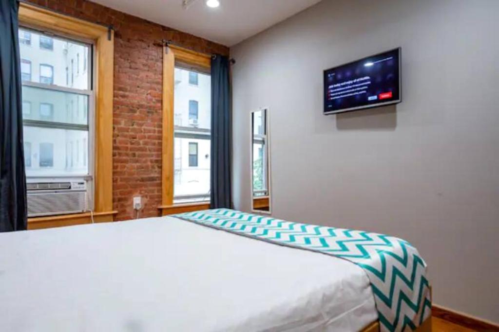 布朗克斯莫里斯旅馆的卧室配有一张床,墙上配有电视。