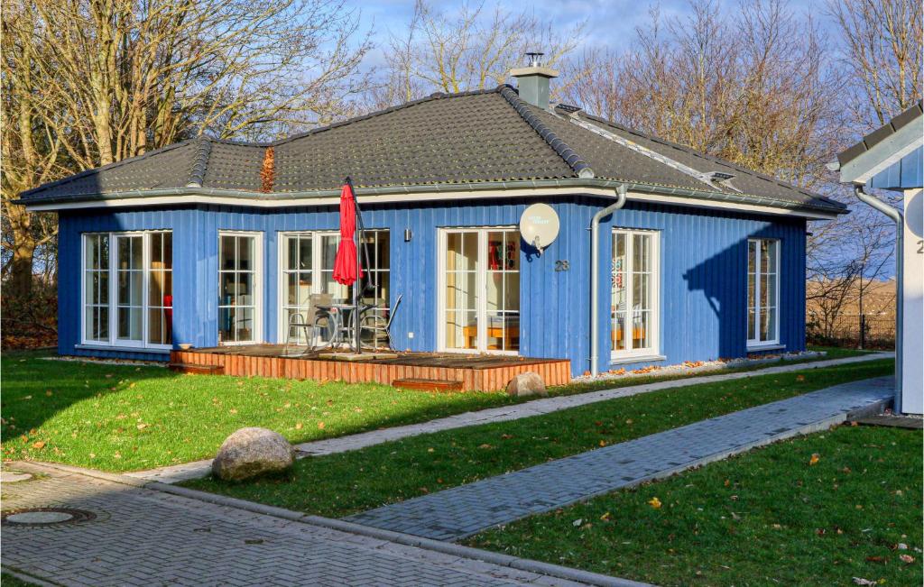 阿尔特费尔Ferienhaus 28 Altefhr的院子里有红旗的蓝色房子