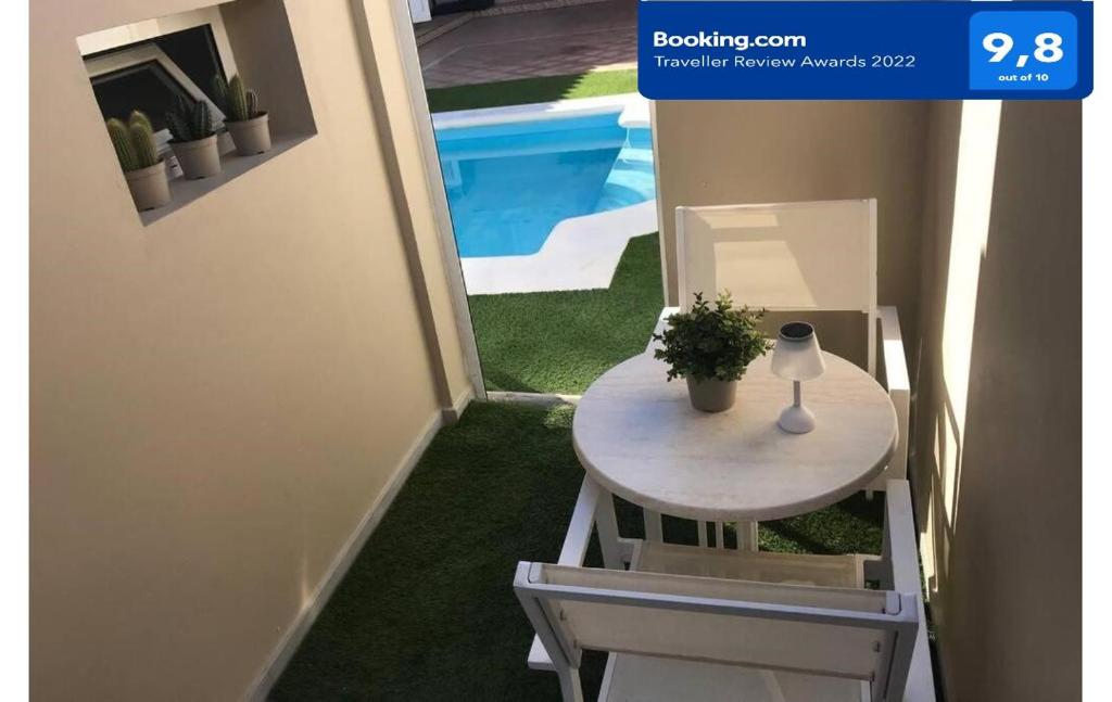 大塔拉哈尔Mar&Mar, apartamento nuevo con solárium y piscina的游泳池旁的桌子上放着植物