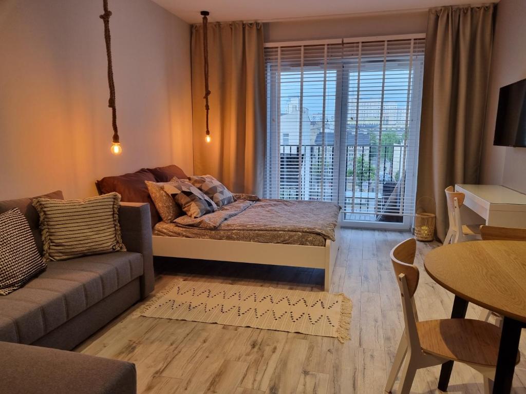 罗兹Apple Apartments - Gdańska PRYWATNE MIEJSCE PARKINGOWE的客厅配有沙发和桌子