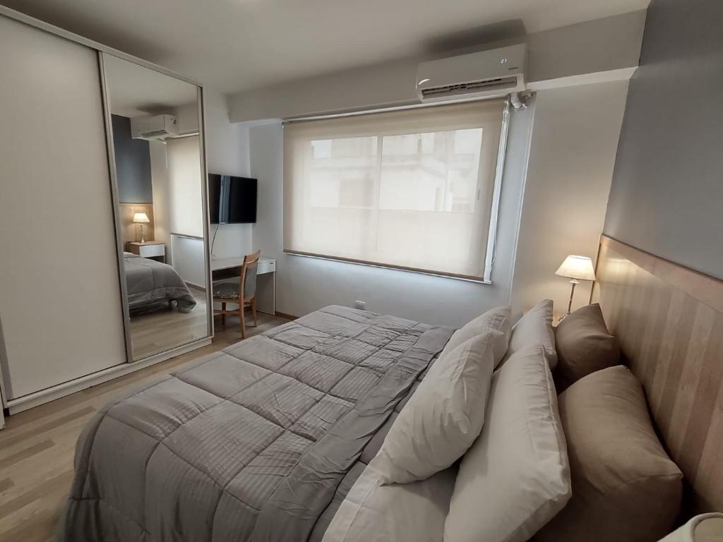 布宜诺斯艾利斯Precioso departamento en el centro de la ciudad的一间卧室设有一张大床和一个大窗户