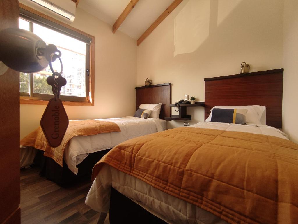 康塞普西翁Hotel Le Petit的一间卧室设有两张床和窗户。