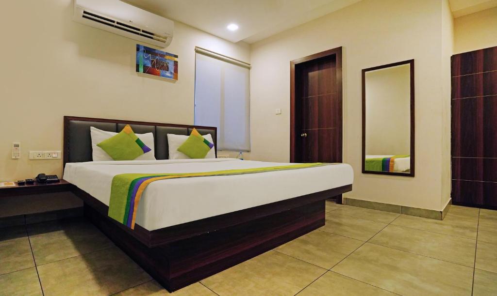 布巴内什瓦尔Treebo Trend Lazystay Grand Patia的一间卧室配有一张大床和镜子