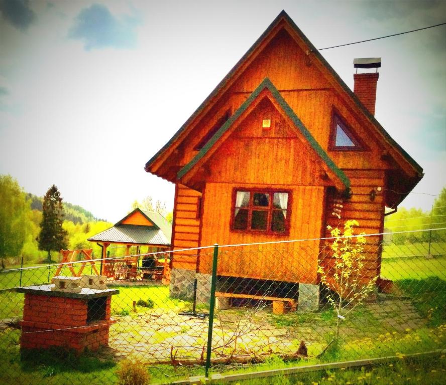 米卢夫卡Zagroda Górska na Zobawie的前面有围栏的小木房子