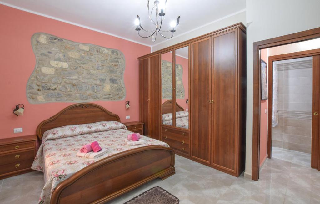 维拉皮亚纳La casetta di nonna Maria的一间卧室配有一张粉红色墙壁的床