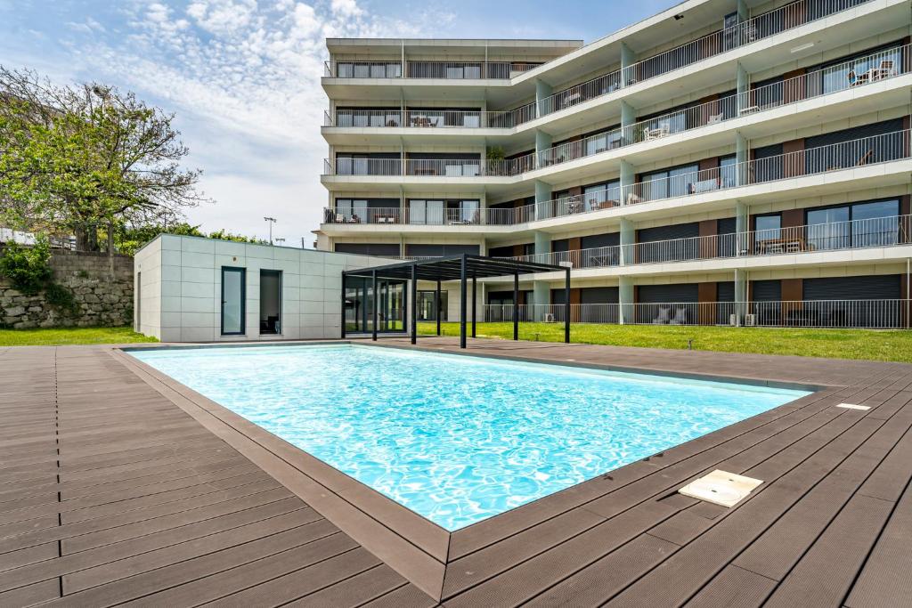 波尔图Antas Park Apartment的大楼前的大型游泳池
