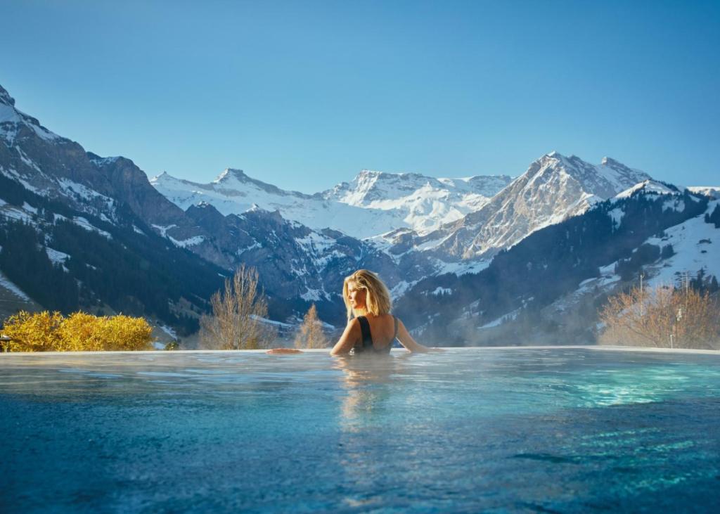 阿德尔博登寒武纪酒店的山区无边游泳池中的女人