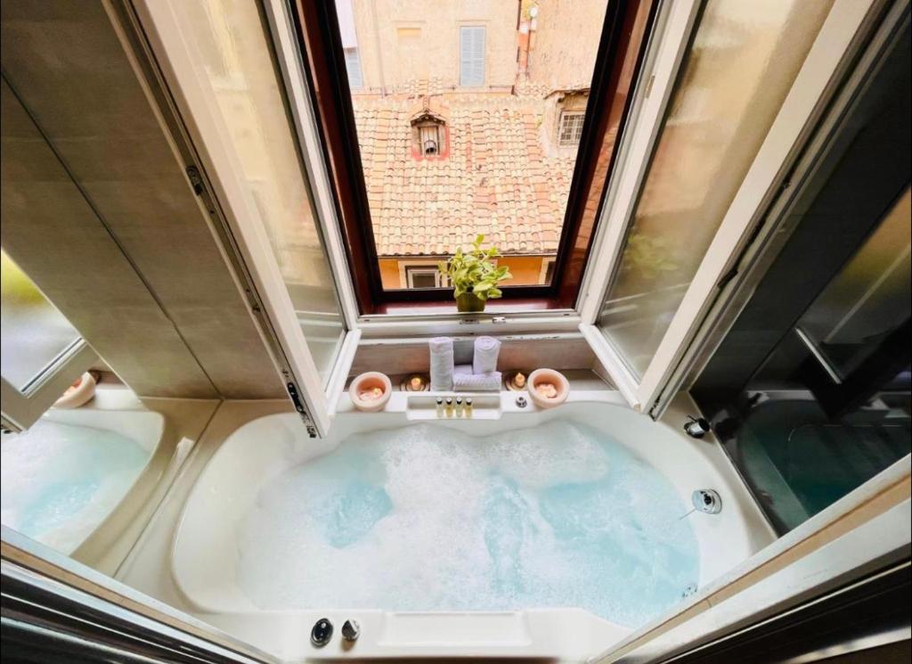 罗马Town House Spagna- luxury Rooms with Jacuzzi Bath的浴缸上方的窗户