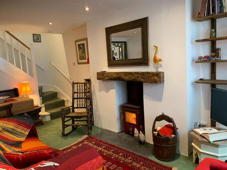 LlangattockCosy holiday cottage in Crickhowell.的客厅设有壁炉和镜子