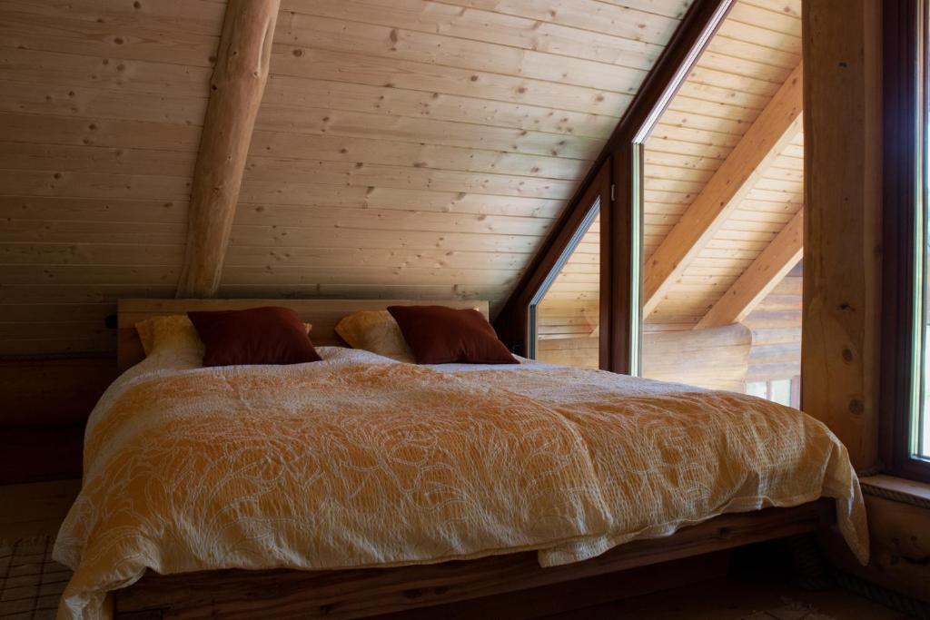 格罗苏普列Brunarica Biopark -Log house Biopark的木天花板的客房内的一张床位