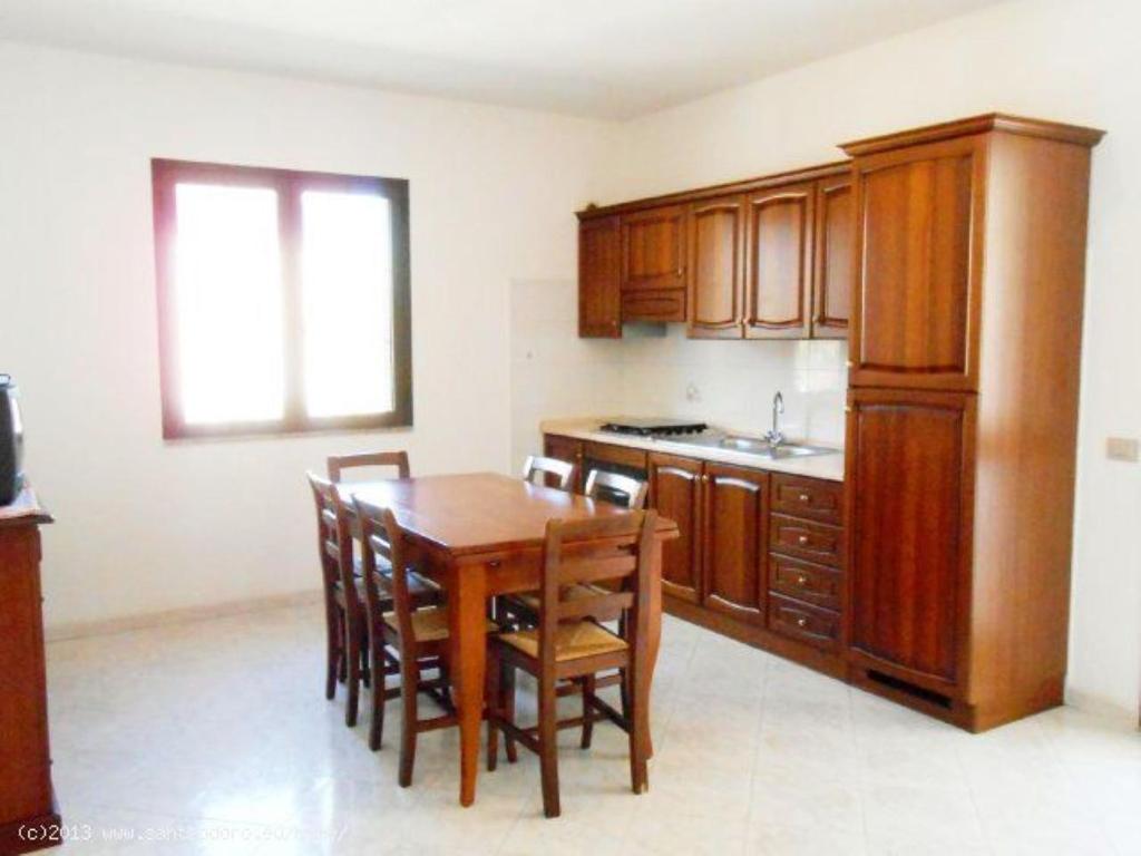 圣特奥多罗Bilo Lu Rattali的厨房配有木桌和木橱柜。