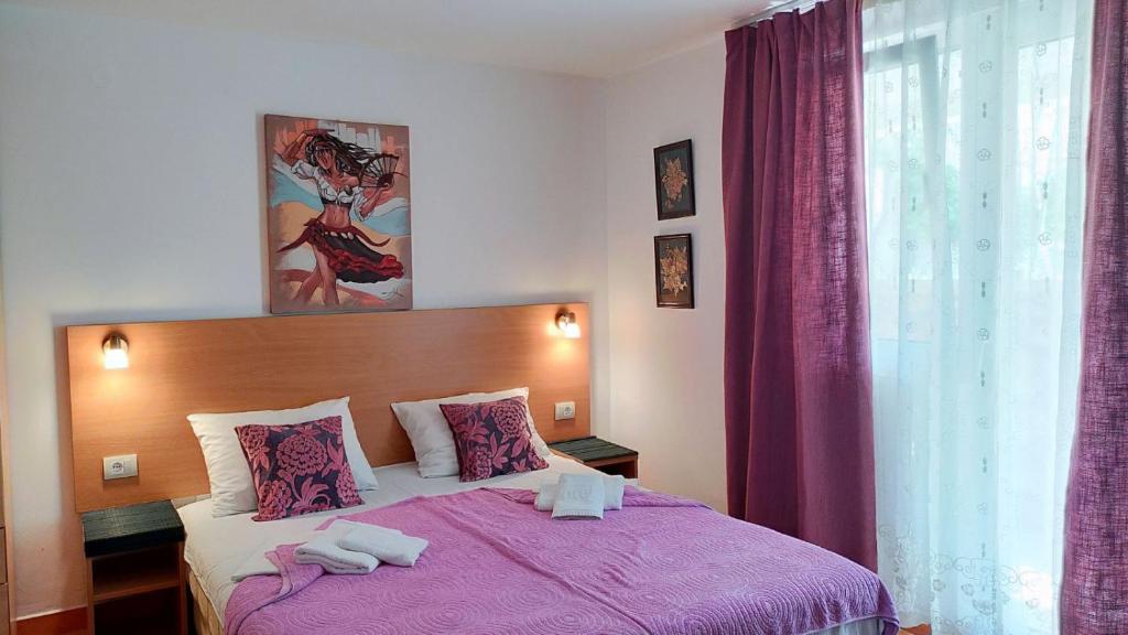贝西奇Guesthouse Tri Palme的一间卧室配有一张紫色床和毛巾