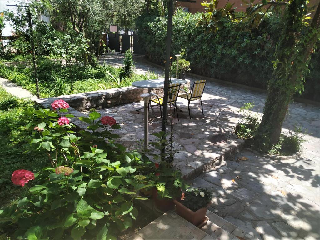 布德瓦Apartmani Abeona的庭院配有桌椅和鲜花