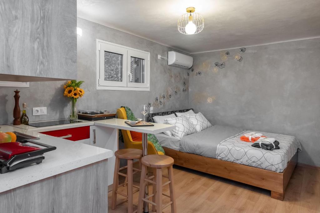 雅典Cozy tiny apartment in the heart of Plaka的一间带床的小卧室和一间厨房