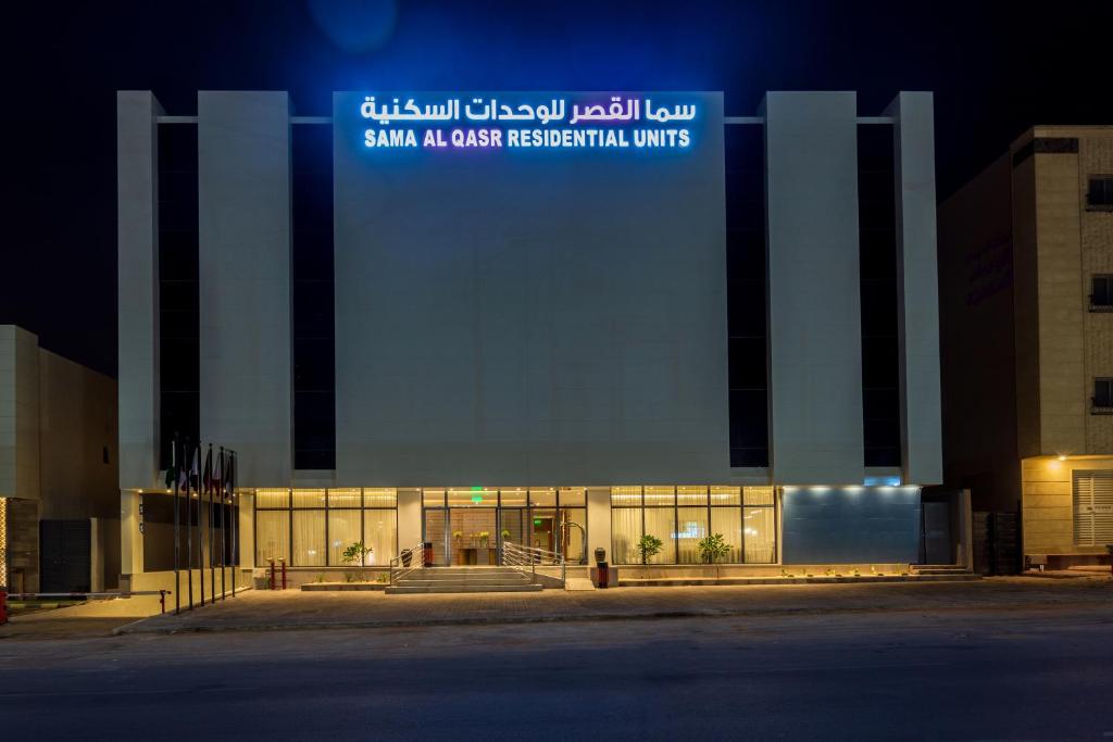 利雅德Sama Al Qasr Hotel Apartments的建筑的侧面有标志
