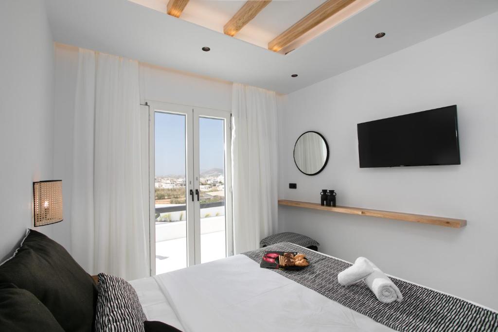 纳克索乔拉Naxos White Concept的卧室配有一张床铺,墙上配有电视