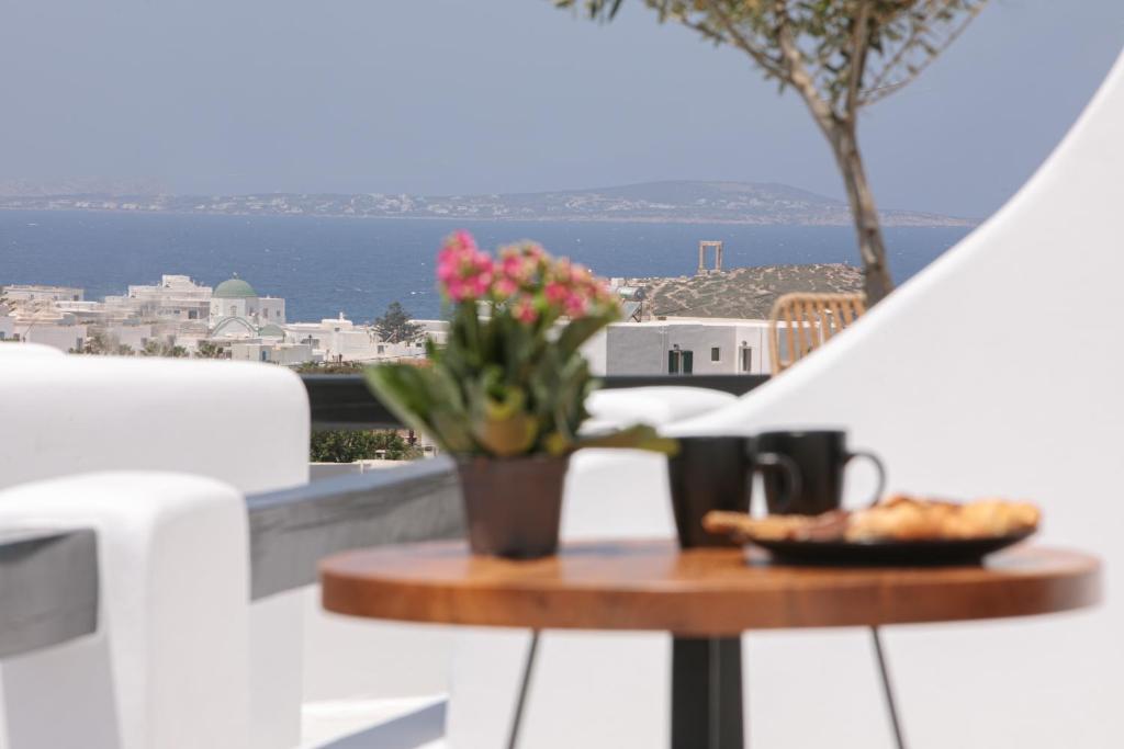 纳克索乔拉Naxos White Concept的阳台上摆放着一盘食物和鲜花的桌子