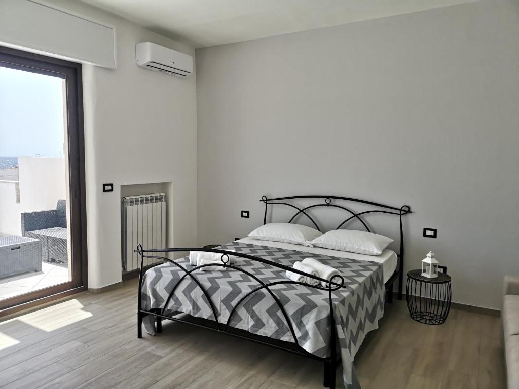 加利波利B&b tra scirocco e tramontana的一间卧室设有一张床和一个大窗户