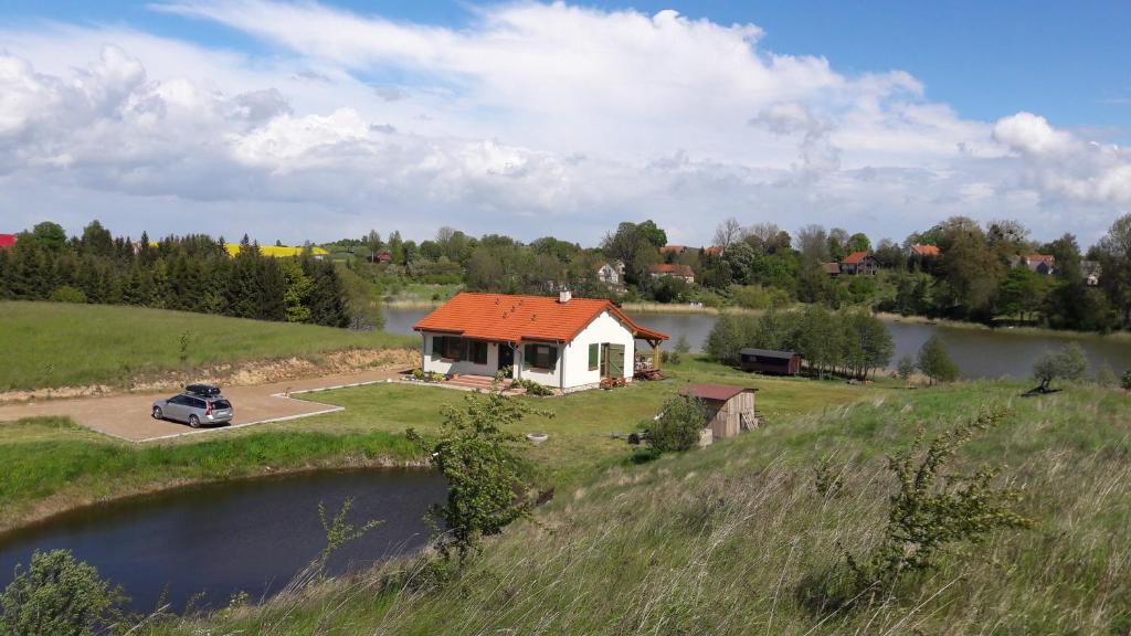 吉日茨科Siedlisko Upałty的湖畔的橙色屋顶房子