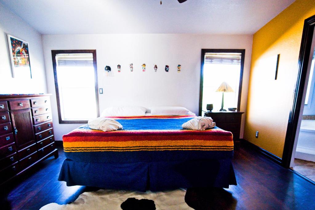 MancosSunny Southwest Cottage的一间卧室配有一张床,里面放着两只狗
