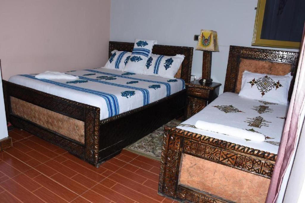 拉利贝拉Blue Nile Guest House的一间卧室配有两张床、一张桌子和一张床边镜。
