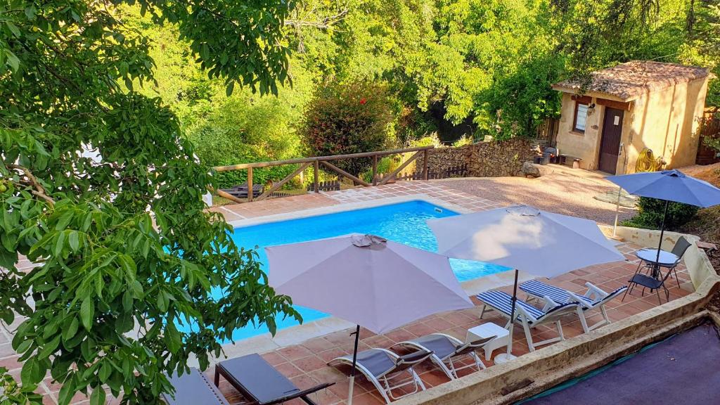 科迪加纳富希奥德米洛斯乡村民宿的游泳池旁配有两把遮阳伞和椅子