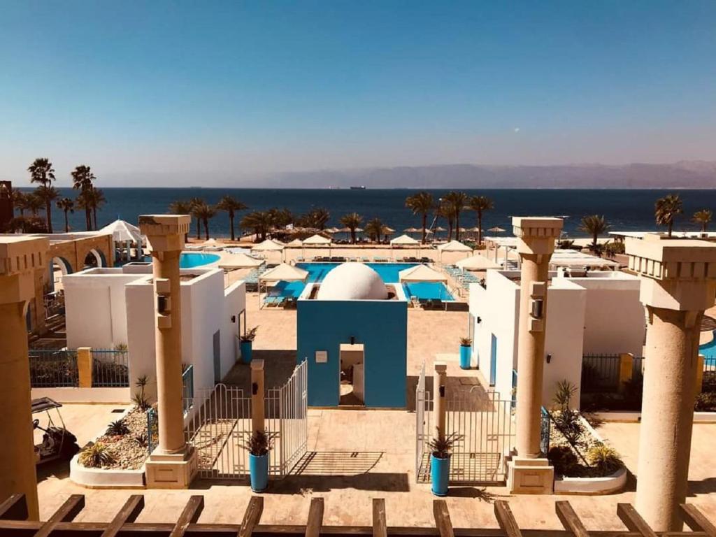 亚喀巴Sea View Apartment at Tala Bay Resort in Aqaba的享有棕榈树度假村和大海的景致。