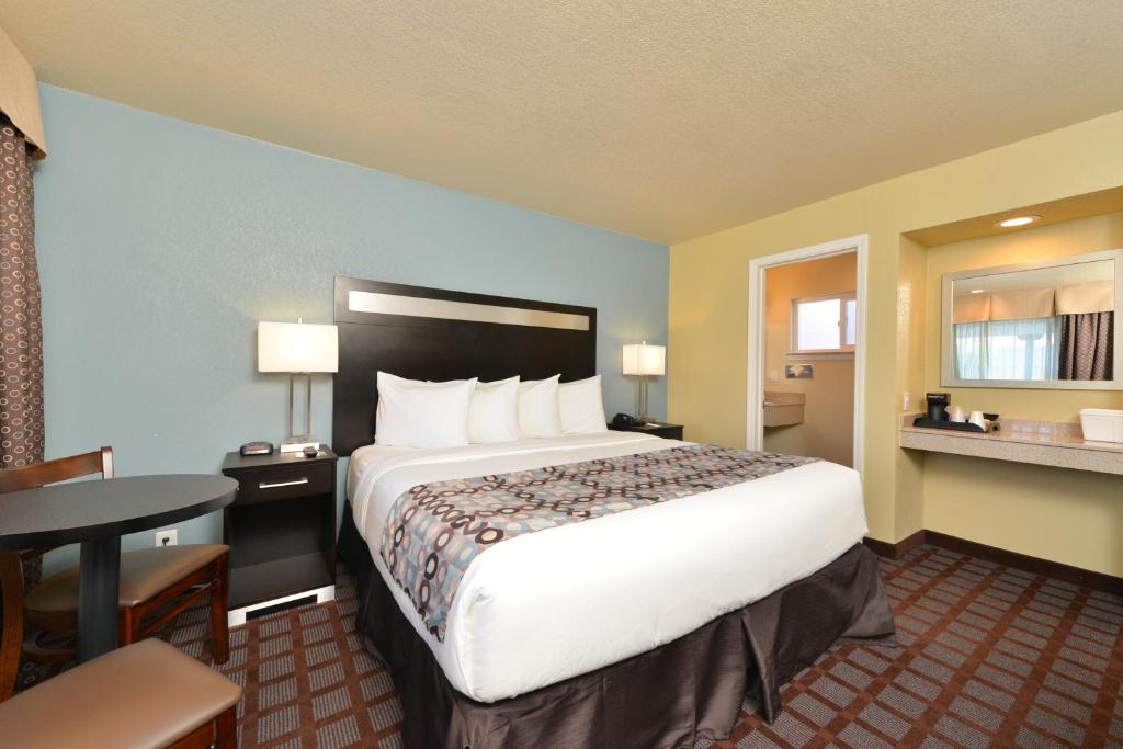 圣路易斯-奥比斯保圣路易斯-奥比斯保市中心大道酒店的酒店客房设有一张大床和一张桌子。