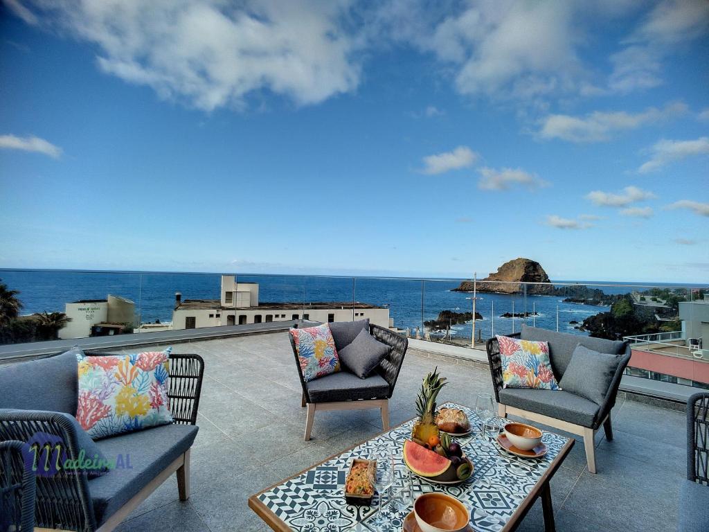 莫尼兹港Pearls Beach Penthouse的一个带桌椅的庭院和大海