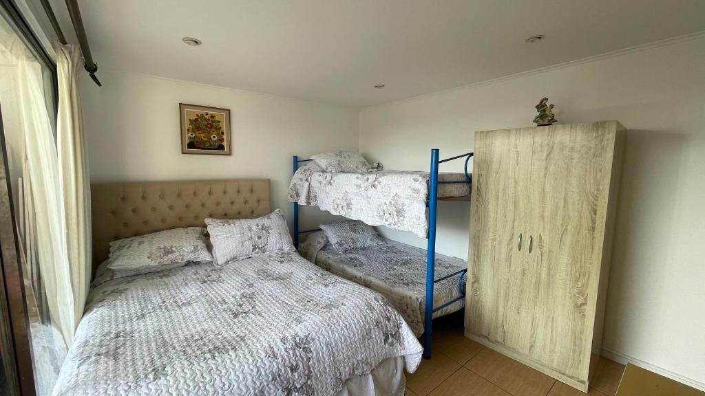 拉塞雷纳Calor De Hogar La Serena的一间卧室设有两张双层床和一扇窗户。