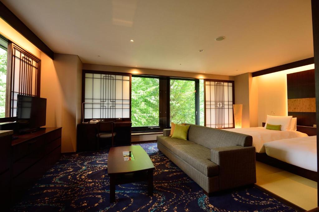 东京龙名馆酒店御茶水总店的酒店客房配有床、沙发和电视。