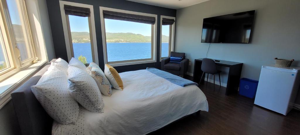 科纳布鲁克Coastal Lookout Suites的一间卧室配有一张床,享有水景