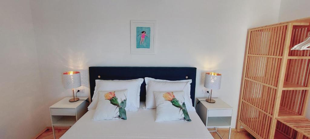 赫瓦尔Vila Luka的一间卧室配有一张带两个枕头和两个灯的床。