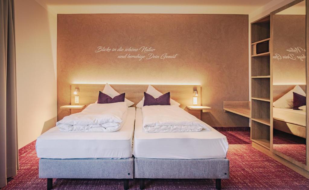 Grasellenbach加斯巴赫塔尔酒店的一间带两张床的卧室和一个架子