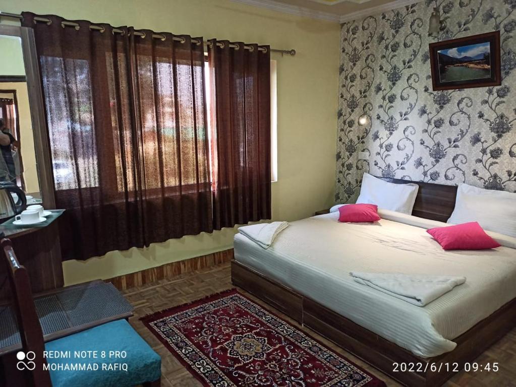 斯利那加Hotel curio's All seasons的一间卧室配有带粉红色枕头的床。