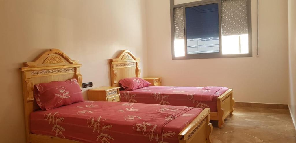 胡塞马appartement boukidan的客房设有两张单人床和一扇窗户。