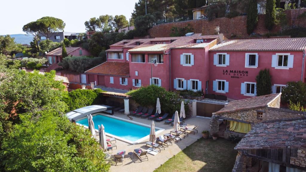 鲁西永La Maison des Ocres - Provence的一座带游泳池和大楼的度假村