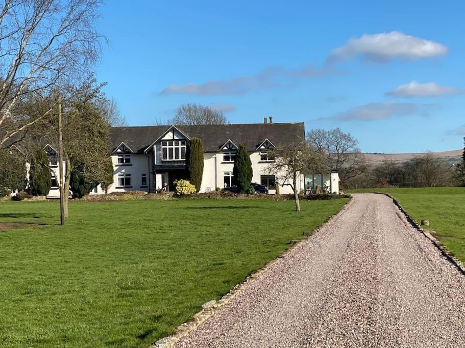AdlingtonSouth Cottage - Garden, Views, Parking, Dogs, Cheshire, Walks, Family的绿色田野上一条土路上的白色大房子