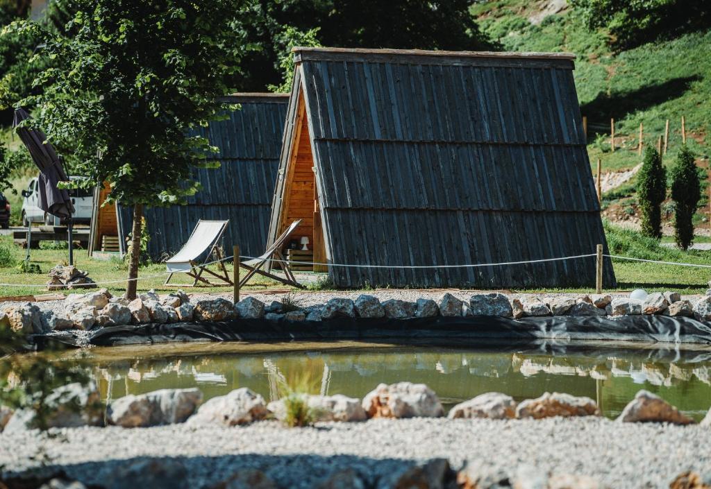 拉多夫吉卡Glamping alp hut in camping Garden Park的小木屋前面设有池塘