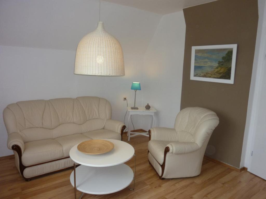 海利根达姆Kleine Sandburg Heiligendamm的客厅配有沙发、两把椅子和一张桌子