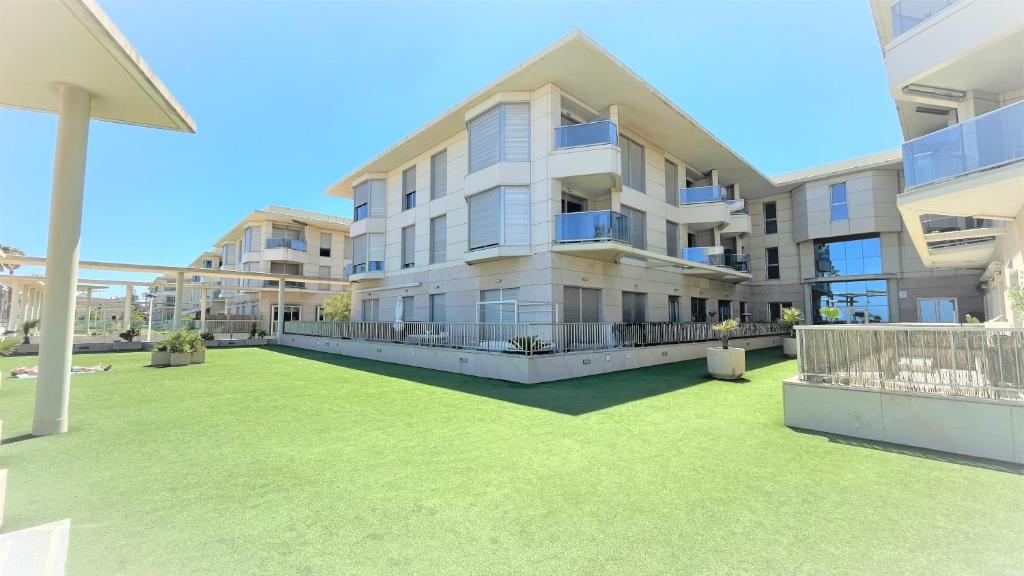 瓦伦西亚BEACH VALENCIA 21 - Luxury Apartament on Beach的一座大型公寓楼,前面设有草坪