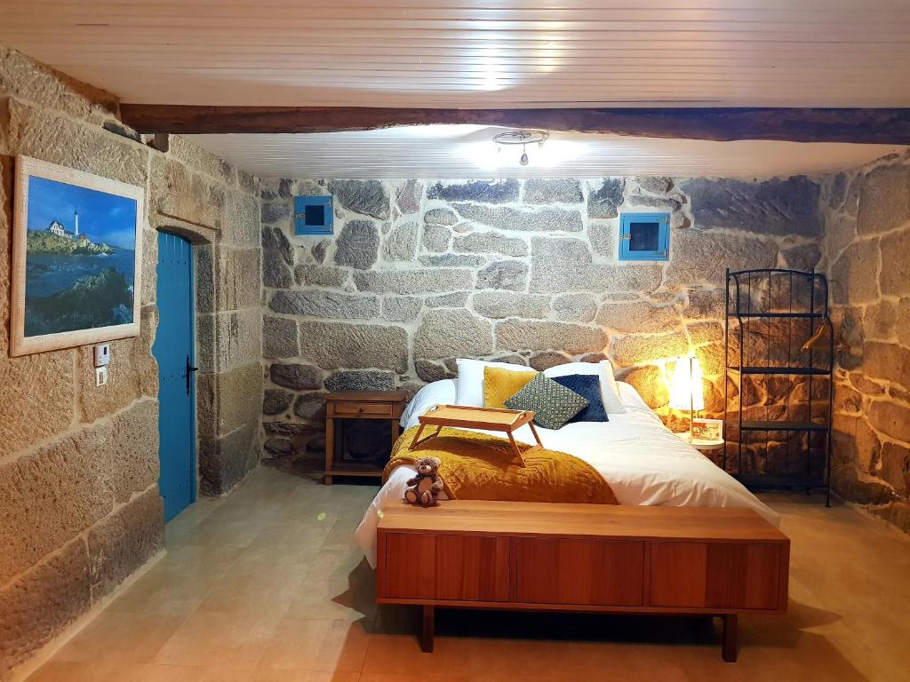 阿拉力兹A aira da xoaniña的卧室配有一张石墙床