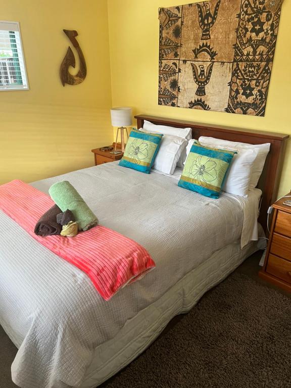 图克劳海滩Karikari Lodge的一间卧室配有一张带枕头的大床