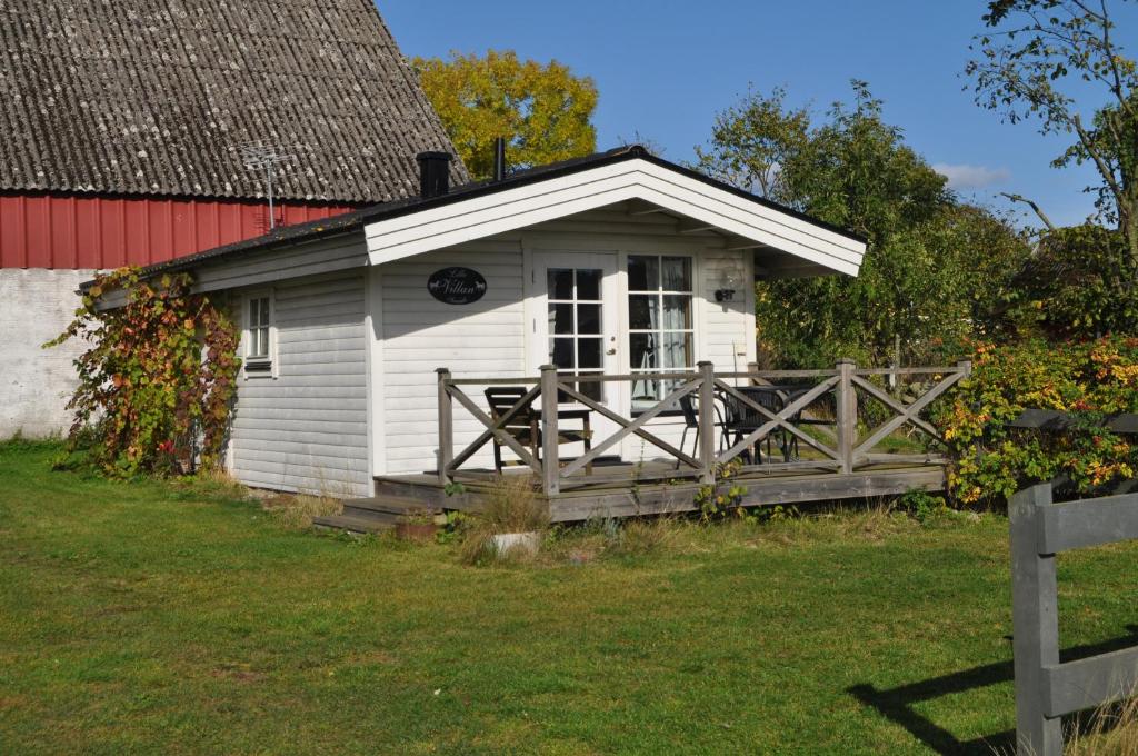 BromöllaRusthållaregården i Edenryd的白色的小小屋,设有红色谷仓