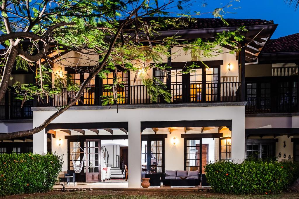 塔马林多Dream House in prestigious Hacienda Pinilla的享有白色房屋外景,设有黑窗