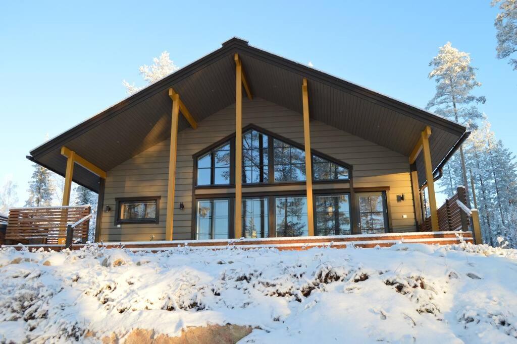 MeltausVilla Vasa - new luxury villa next to lake的树林里的雪地里的木屋