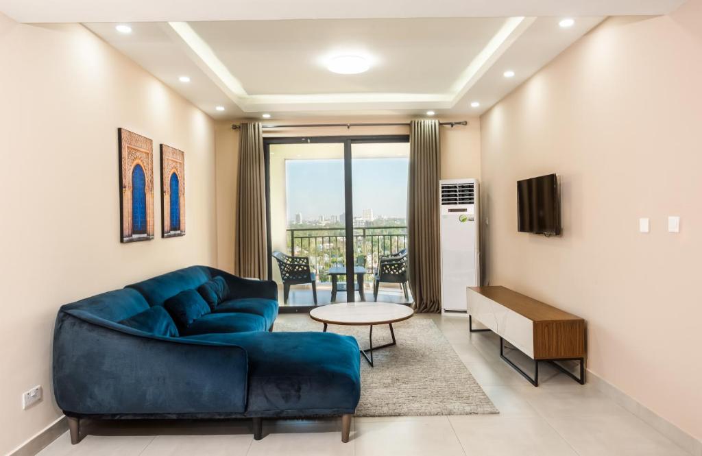 达累斯萨拉姆PALMVILLAGE MIKOCHENI的客厅配有蓝色的沙发和桌子