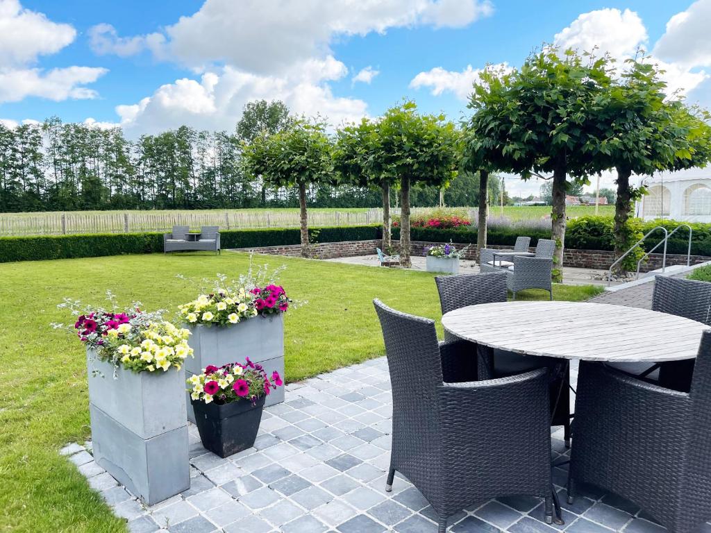 WervikHotel het Elsland的庭院配有桌椅和鲜花