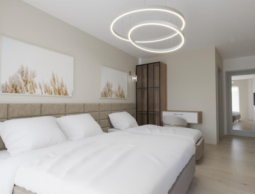 斯特鲁加Struga Riverview Hotel的卧室配有2张白色的床和吊灯。
